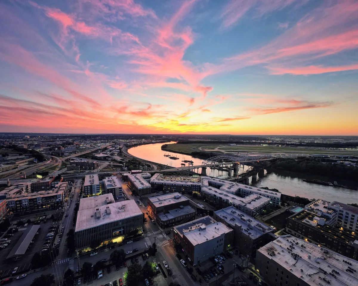 Kansas City riverfront and the Missouri River beneath a warm sky.